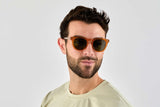 Man wearing Sunset, Orange Round-Square Sunglasses with Polarized Green Lenses