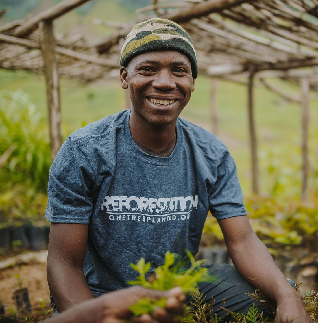 A man smiling and planting trees